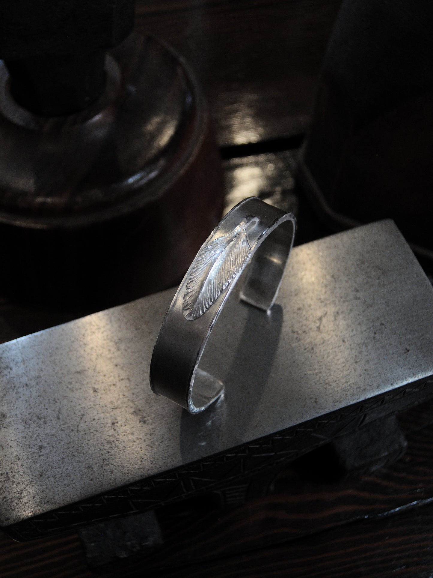 A hand made sterling silver cuff made using repousse and chasing technique. A feather is placed at the center.