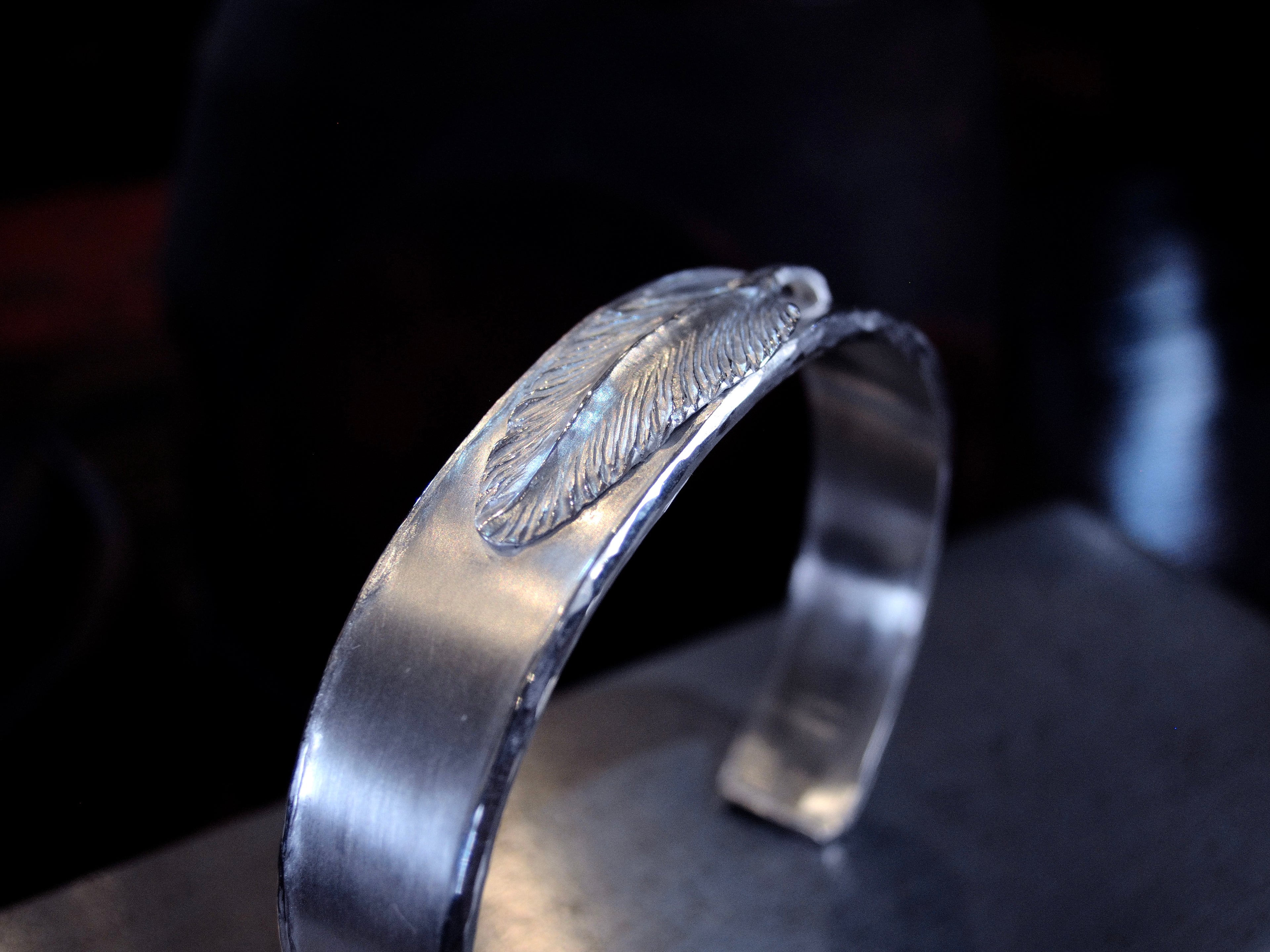 A sterling silver feather cuffs made using traditional repousse and chasing techniques