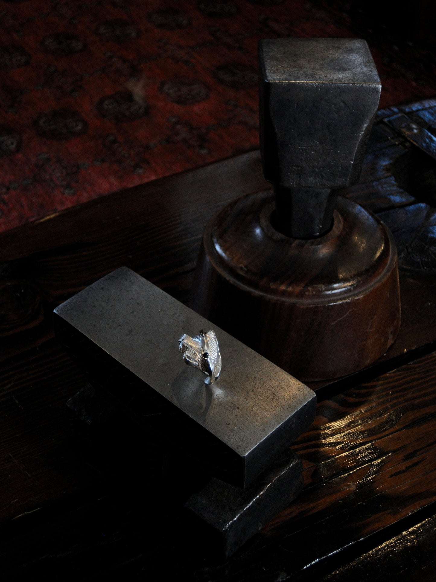 A sterling silver feather ring made using traditional repousse and chasing techniques. It is set with a blue sapphire.