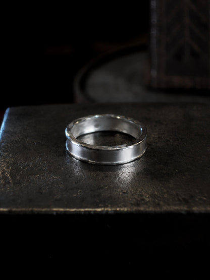 Hammer textured ring featuring hand forged border in sterling silver.