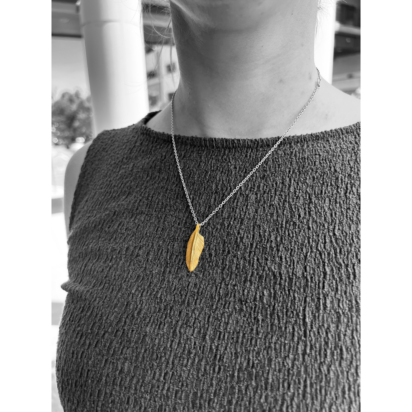 Showcasing a 22k gold feather charm