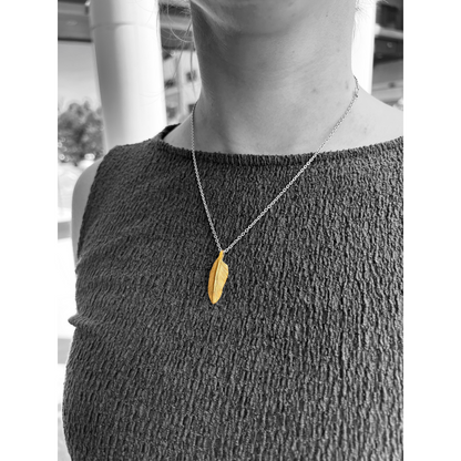 Showcasing a 22k gold feather charm
