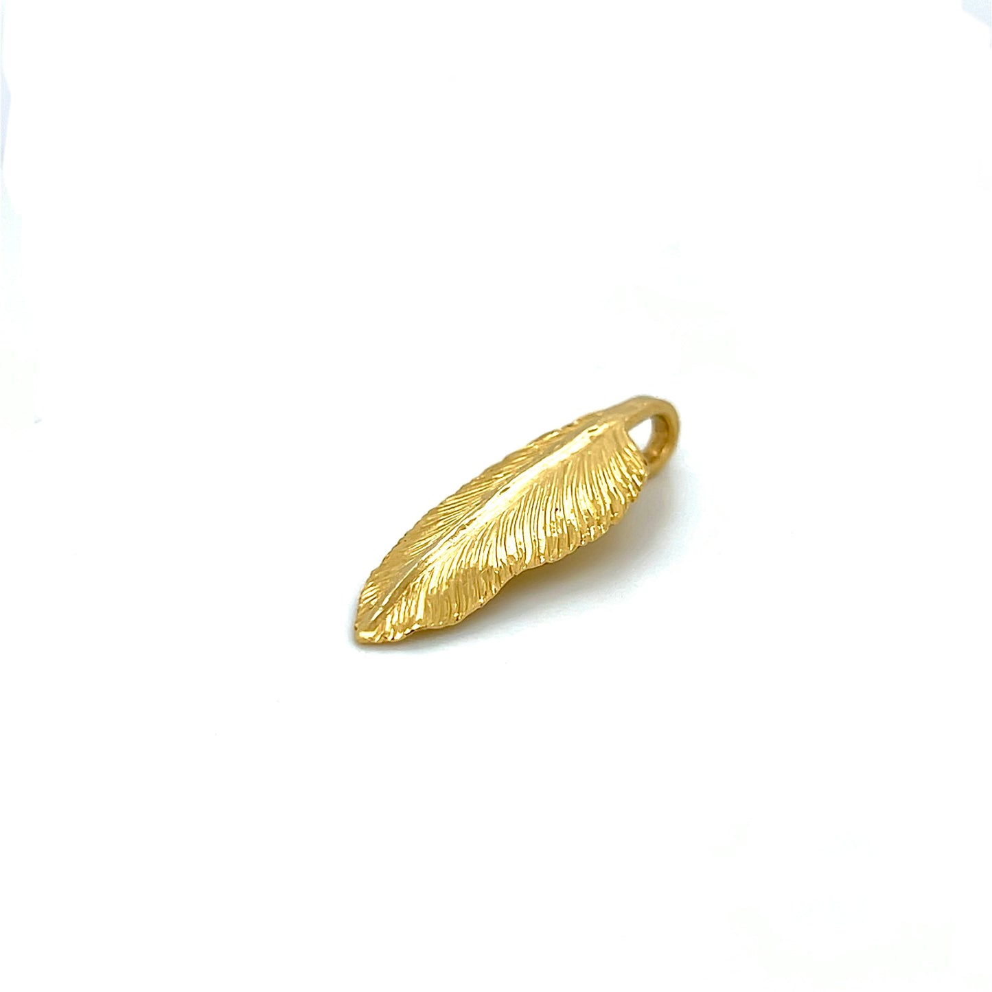 A 22k gold feather charm made using repousse and chasing techniques