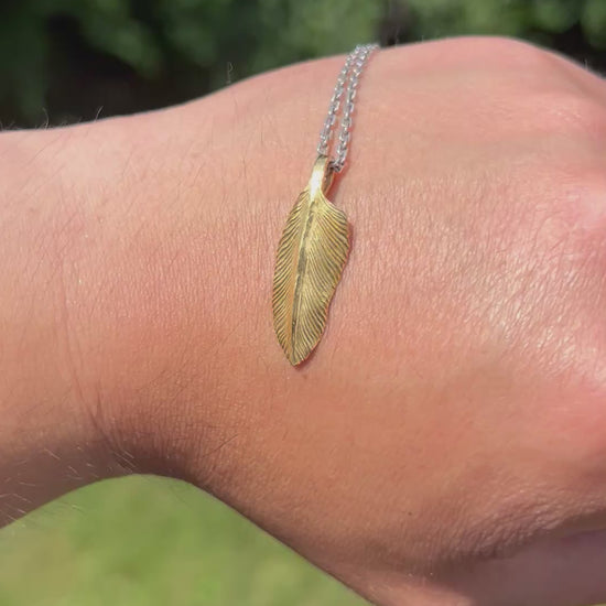 showcase a 22k gold feather charm