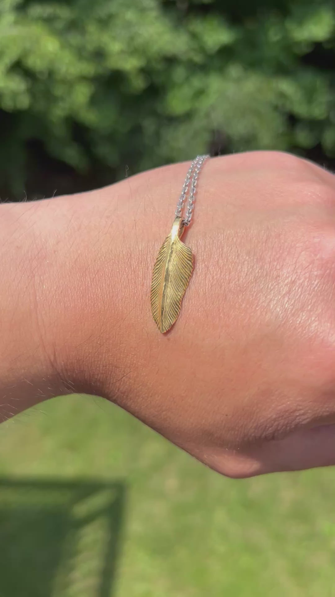 showcase a 22k gold feather charm