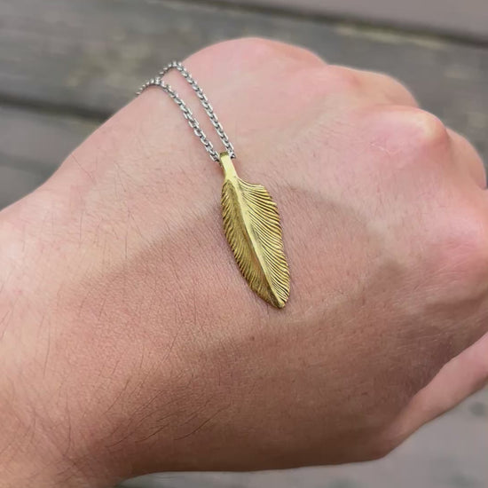 showcase a 22k gold feather charm.
