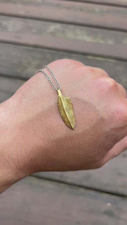 showcase a 22k gold feather charm.