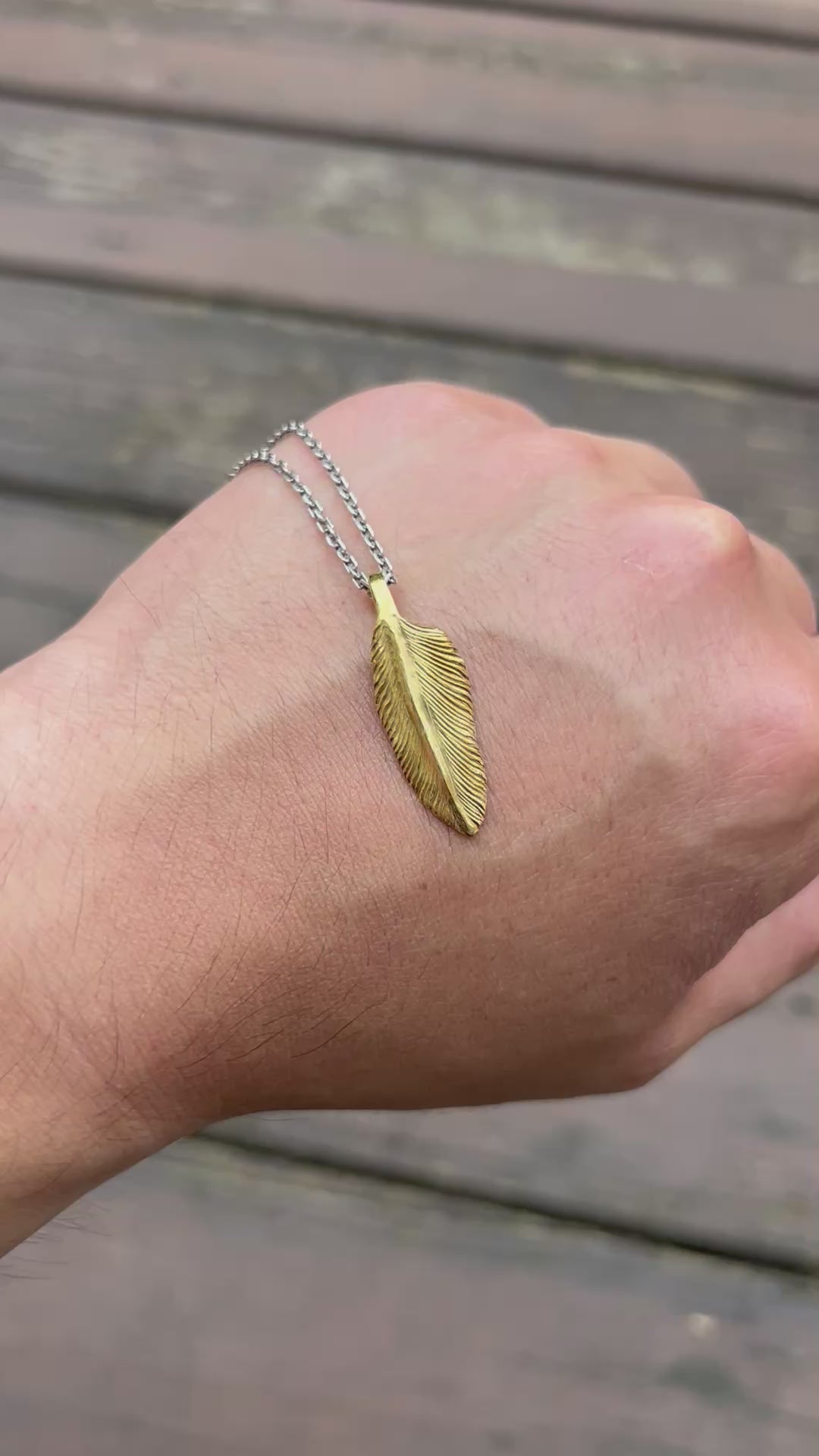 showcase a 22k gold feather charm.