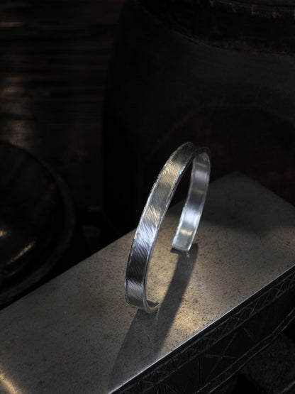 Hammer textured cuff featuring water-like texture and hand forged border in sterling silver.
