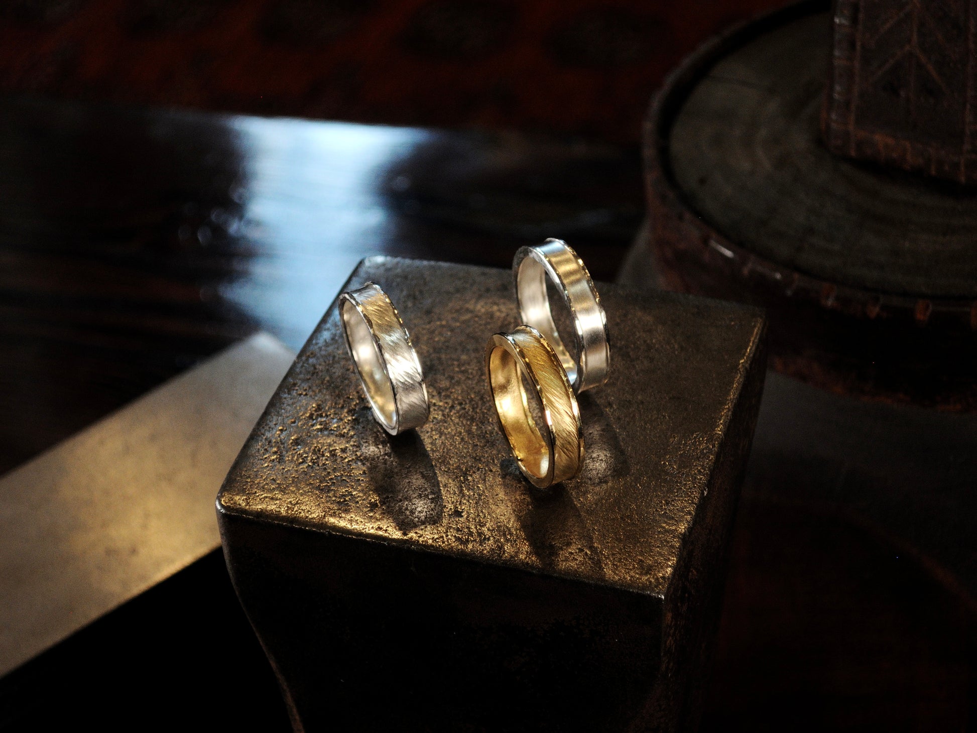 Hammer textured ring featuring water-like texture and hand forged border in 22k yellow gold and sterling silver.